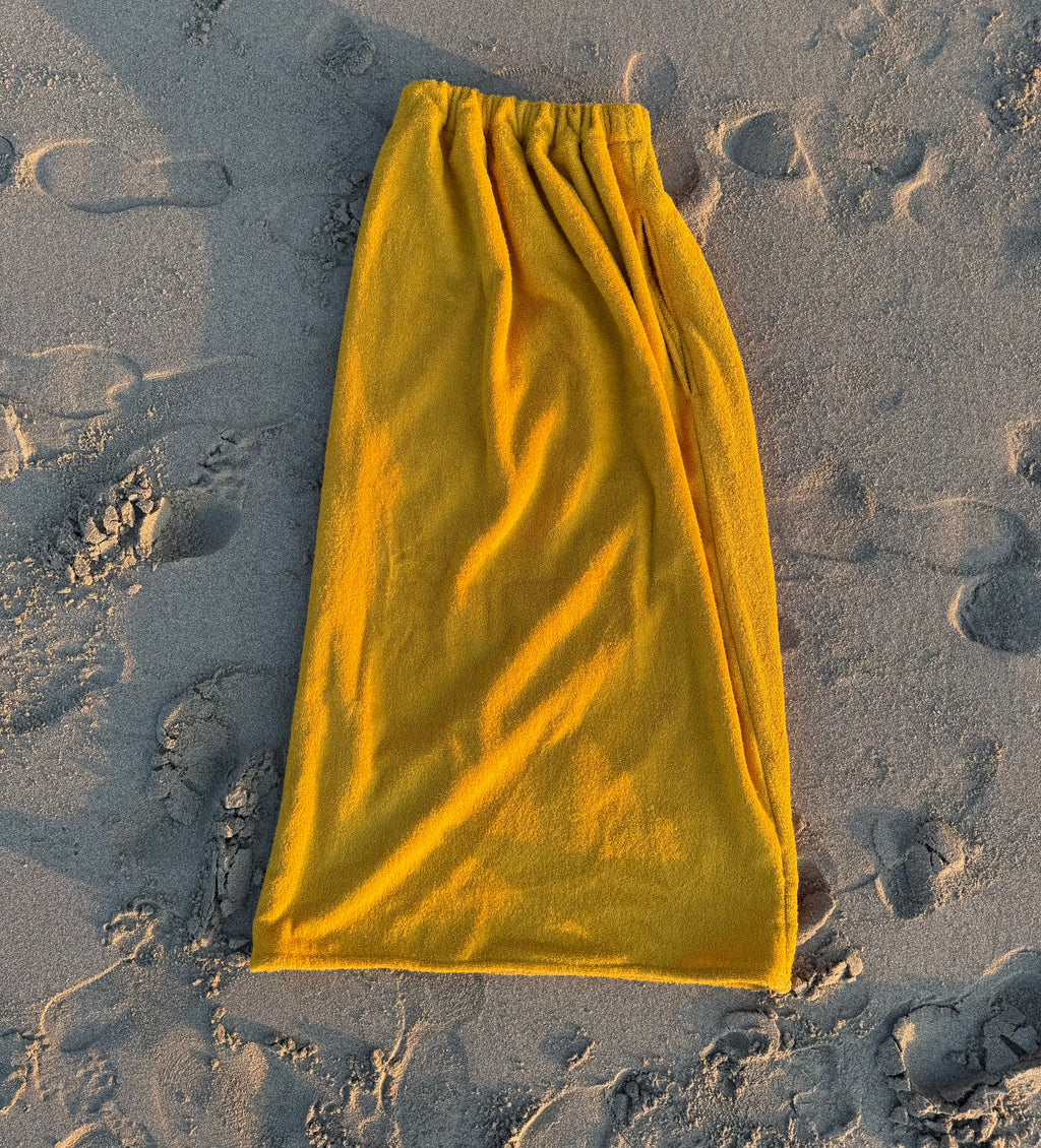 Yellow towel on sandy ground
