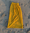 Yellow towel on sandy ground